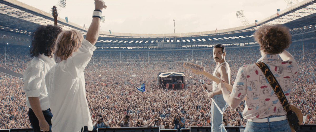 Screenshot 2026-06-05 111048 four band members stand on stage looking out over a full wembley stadium of people.